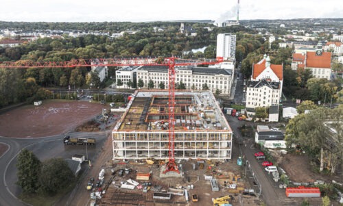 Baustelle von oben mit einem roten Kran