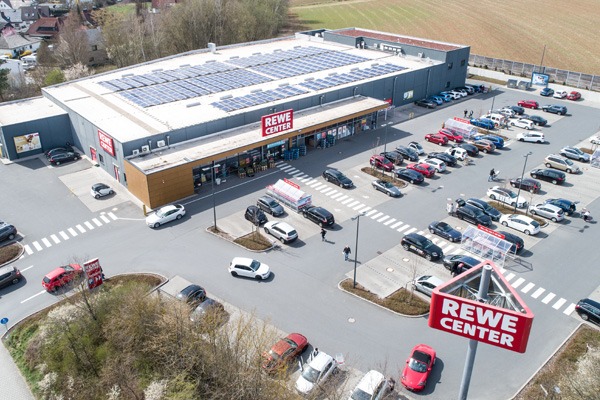 Drohnenaufnahme eines Rewe Center Gebäudes mit Parkplatz