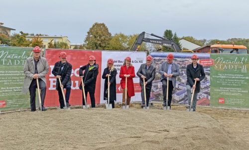 8 Personen halten eine Schaufel in der Hand