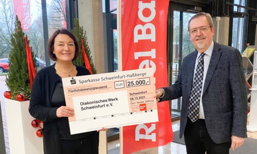 Jochen Kessler-Rosa und Stefanie Riedel halten einen Sparkassenscheck über 25000 € in der Hand