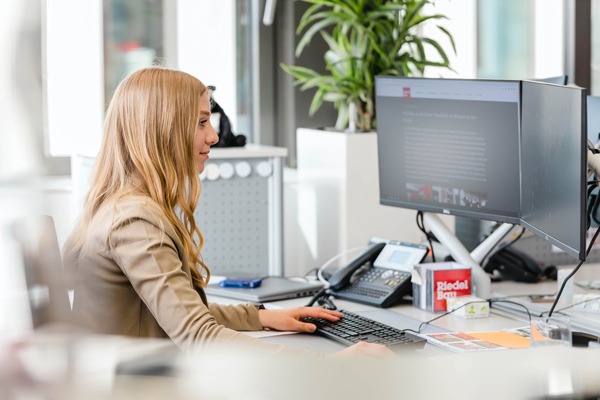 eine junge Frau arbeitet am PC