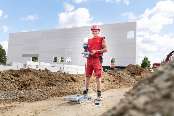 Ein Junger Mann steht vor einer Baustelle