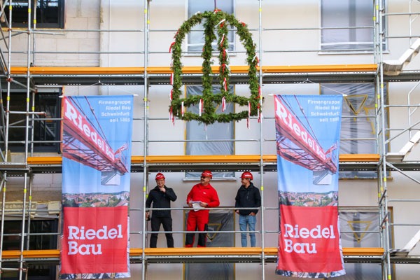 Riedel Bau Mitarbeitende beim Halten eines Richtspruchs