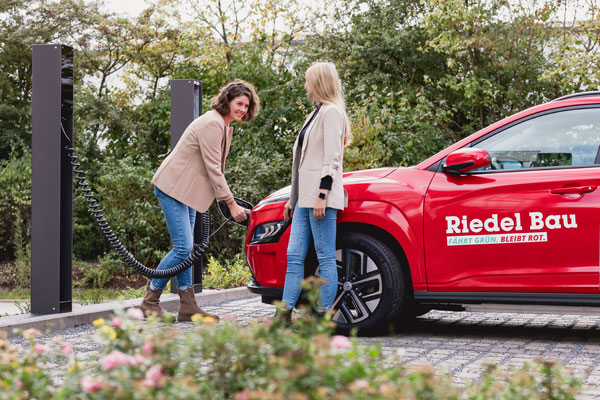 Mitarbeitende beim Laden eines E-Autos