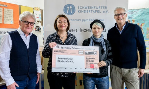 4 Personen halten einen Scheck für die Kindertafel über 5.000 Euro in der Hand.