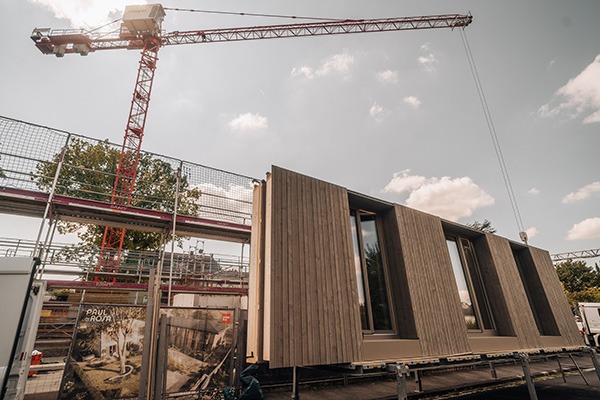 Montage eines vorgefertigten Holzbau-Moduls auf der Baustelle