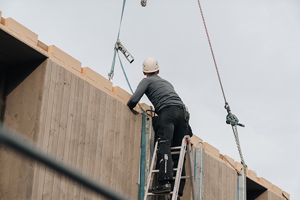 Montagearbeiten an der Holzfassade eines Gebäudes